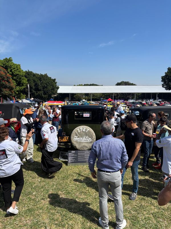Asistentes recorriendo la exhibición de automóviles